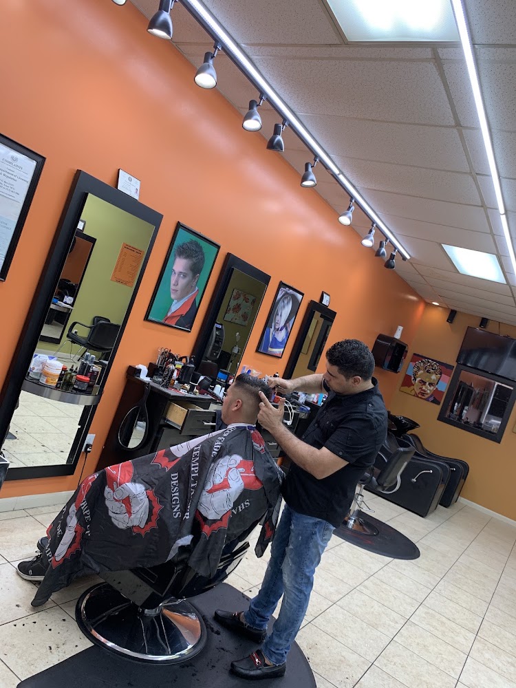 Barber working on a client under warm track lighting